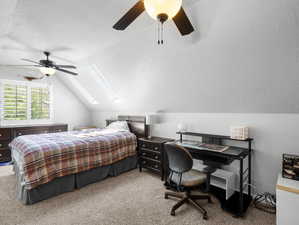 Spare room featuring a textured ceiling, lofted ceiling with skylight, and ceiling fan