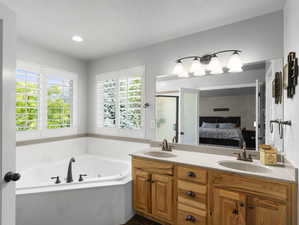 Bathroom featuring double vanity, plus walk in shower, and a textured ceiling