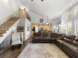 Living room featuring high vaulted ceiling, dark hardwood / wood-style floors, and ceiling fan