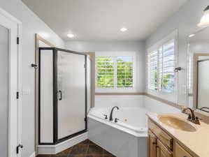 Bathroom featuring tile patterned floors, plus walk in shower, vanity, and a textured ceiling