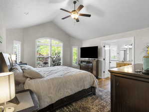 Bedroom with wood-type flooring, vaulted ceiling, and ceiling fan