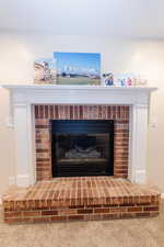 Room details featuring carpet flooring and a fireplace