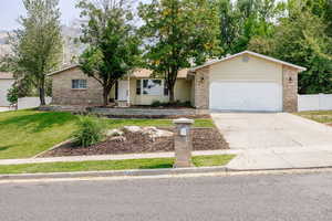 Ranch-style home with a front lawn and a garage