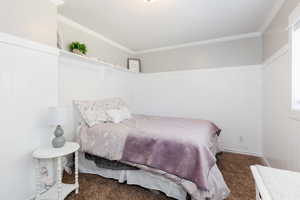 Bedroom featuring dark colored carpet and ornamental molding