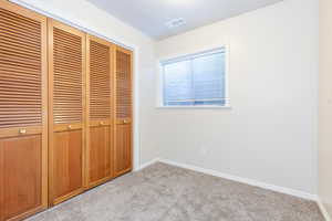 Unfurnished bedroom with a closet and light colored carpet