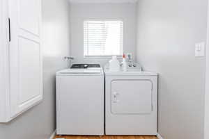 Laundry room featuring separate washer and dryer and light wood-type flooring