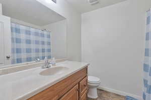 Bathroom with tile patterned floors, vanity, and toilet