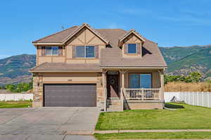 View of front facade with a garage, a mountain view, and a front yard