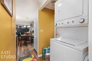 Washroom featuring stacked washer / dryer and dark hardwood / wood-style floors