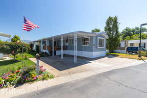 Manufactured / mobile home featuring a carport and a front yard