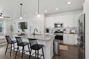 Kitchen featuring white cabinets, dark hardwood / wood-style flooring, appliances with stainless steel finishes, and sink