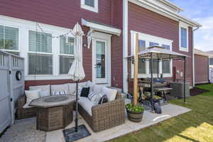 View of patio featuring an outdoor living space with a fire pit, central AC, and a gazebo