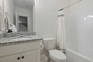 Full bathroom featuring vanity, toilet, and shower / tub combo with curtain