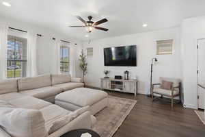 Living room with dark hardwood / wood-style floors and ceiling fan