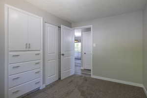 Unfurnished bedroom with carpet floors and a textured ceiling