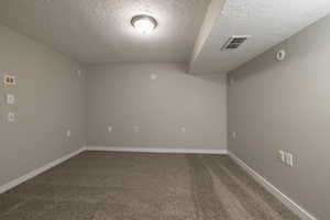 Carpeted media room/ office with a textured ceiling