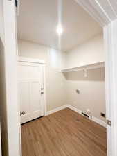 Clothes washing area with hookup for a washing machine, light hardwood / wood-style floors, and gas dryer hookup