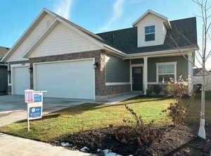 View of front facade with a garage and a front lawn