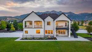 Back of house at dusk with a patio, two decks, a fire pit and a stunning mountain view.