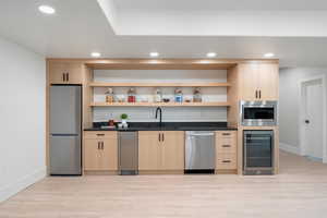 Second kitchen featuring appliances with stainless steel finishes, sink, beverage cooler, ice maker and microwave.