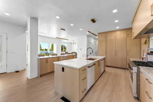 Kitchen featuring double islands, quartzite countertops and double dishwashers.