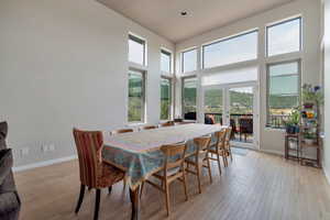 Dining space with light wood-type flooring, french doors, and a towering ceiling