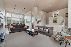 Living room with hardwood / wood-style flooring and a towering ceiling