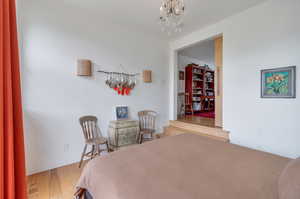 Bedroom featuring wood-type flooring and a chandelier