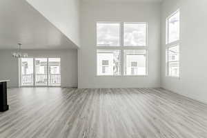Unfurnished living room with a textured ceiling, a high ceiling, and a wealth of natural light