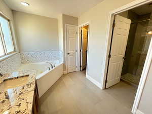 Bathroom with vanity, plus walk in shower, and tile patterned flooring