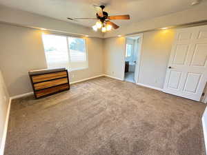 Unfurnished bedroom with connected bathroom, carpet, and ceiling fan