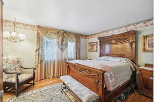 Bedroom featuring a notable chandelier and hardwood / wood-style flooring