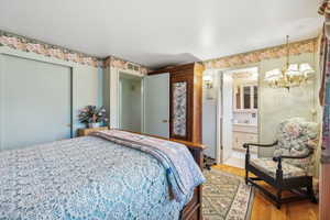 Bedroom with hardwood / wood-style flooring and connected bathroom