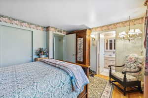 Bedroom featuring ensuite bathroom and wood-type flooring