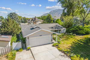 Exterior space with a mountain view, a garage, and a front lawn