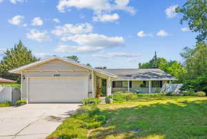 Ranch-style house with a garage and a front lawn