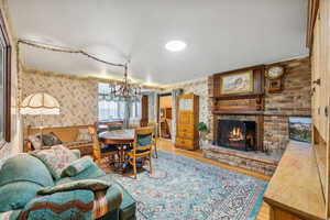 Living room with a brick fireplace, hardwood / wood-style flooring, and a chandelier