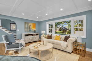 Living room with light hardwood / wood-style flooring and coffered ceiling