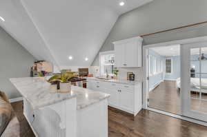 ADU Kitchen with white cabinets, sink, a kitchen island, decorative backsplash, and dark hardwood / wood-style flooring