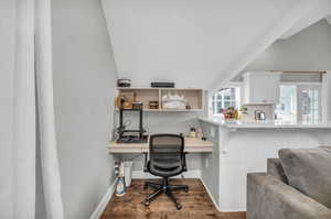 ADU Office with built in desk, hardwood / wood-style flooring, and lofted ceiling