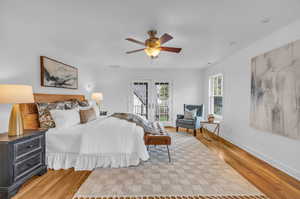 Primary Bedroom featuring access to outside, light hardwood / wood-style flooring, french doors, and ceiling fan