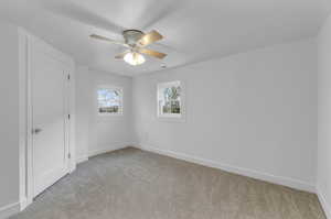 Carpeted empty room featuring ceiling fan