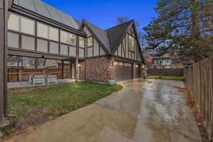 Property exterior at dusk featuring a garage, a yard, and solar panels