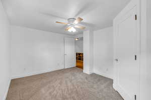 Upstairs Unfurnished bedroom with carpet flooring and ceiling fan