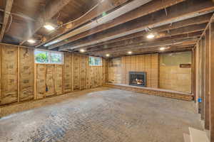 Basement featuring brick wall and a fireplace