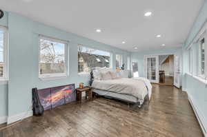 Sunroom with multiple windows, french doors, dark hardwood / wood-style flooring, and a baseboard heating unit