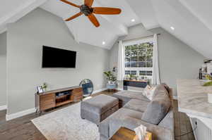 Living room featuring vaulted ceiling, ceiling fan, and dark hardwood / wood-style floors