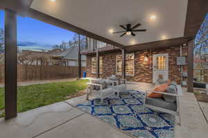 Patio terrace at dusk with an outdoor living space, a balcony, and ceiling fan