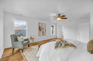 Primary Bedroom with light hardwood / wood-style floors and ceiling fan