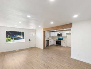 Unfurnished living room featuring sink and light wood-type flooring